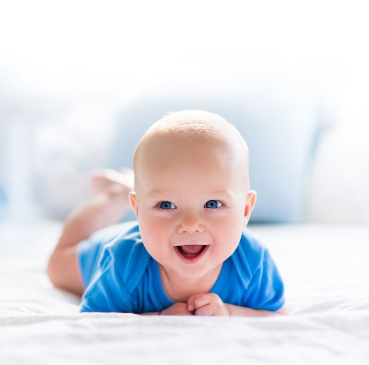 Neonato sorridente su una coperta bianca
